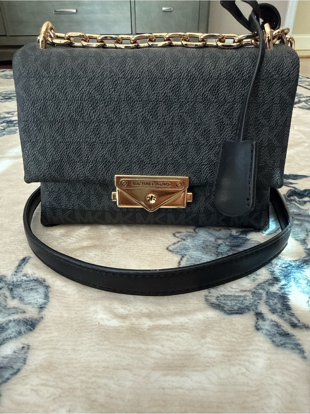 Michael Kors Black monogrammed Leather mini crossbody Bag with Gold Chain.